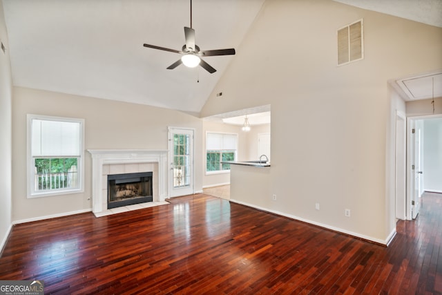 unfurnished living room featuring ceiling fan, high vaulted ceiling, hardwood / wood-style flooring, and a fireplace