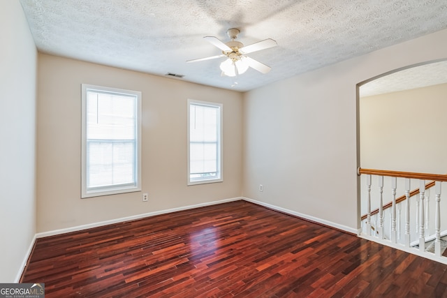 unfurnished room featuring a wealth of natural light, ceiling fan, a textured ceiling, and hardwood / wood-style flooring