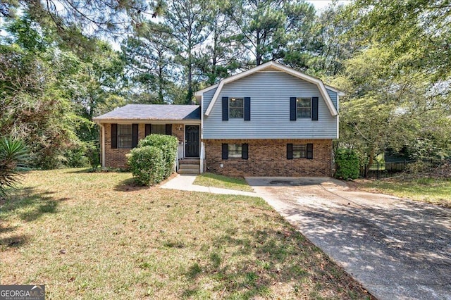 tri-level home featuring a front lawn, concrete driveway, brick siding, and a gambrel roof