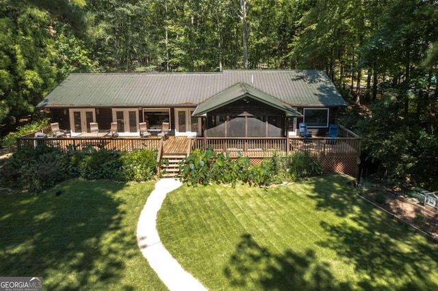 view of front facade featuring a front yard, french doors, metal roof, and a wooden deck