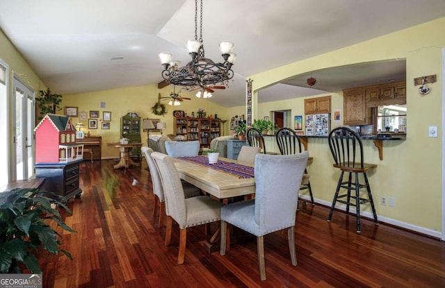 dining area featuring dark hardwood / wood-style floors, vaulted ceiling, and a notable chandelier