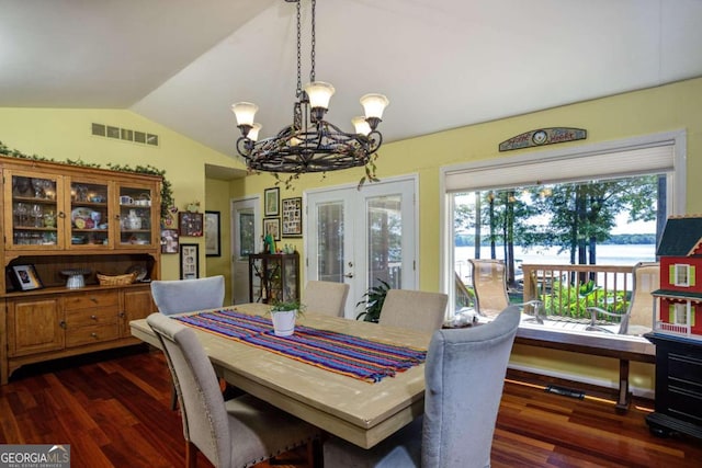 dining area featuring a notable chandelier, dark wood-type flooring, vaulted ceiling, and french doors