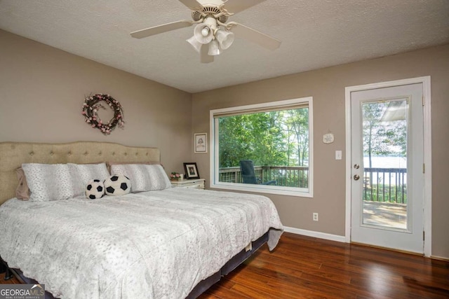 bedroom with ceiling fan, access to outside, dark wood-type flooring, and a textured ceiling