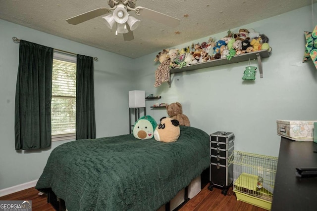 bedroom featuring ceiling fan, hardwood / wood-style floors, and multiple windows