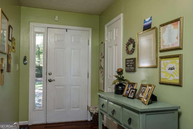 entryway featuring a textured ceiling and dark hardwood / wood-style floors