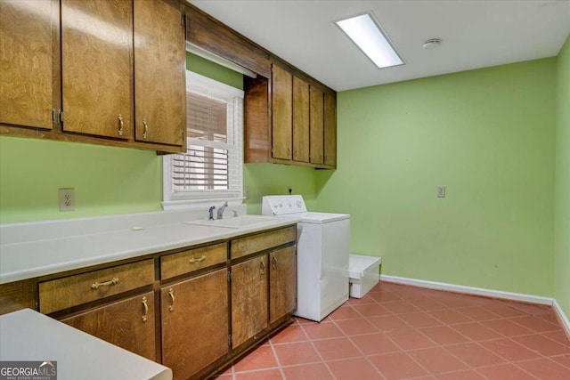 clothes washing area with sink, washer / dryer, cabinets, and light tile patterned floors