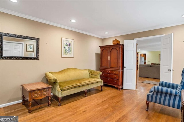 living area featuring light hardwood / wood-style flooring and ornamental molding