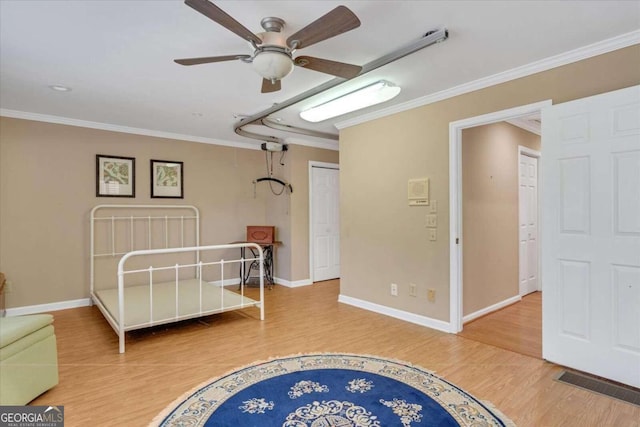 bedroom featuring hardwood / wood-style flooring, ornamental molding, a closet, and ceiling fan