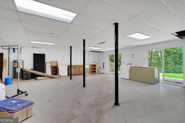 basement featuring water heater, a paneled ceiling, and washer and clothes dryer