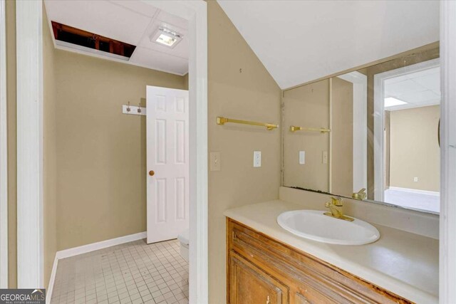 bathroom with toilet, vanity, and tile patterned floors