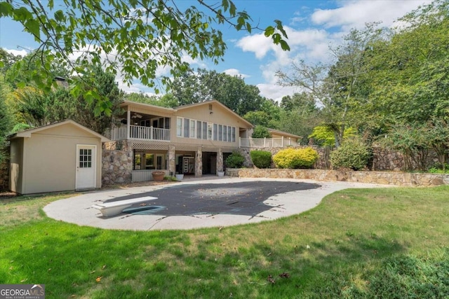 back of house featuring a lawn and an outdoor structure