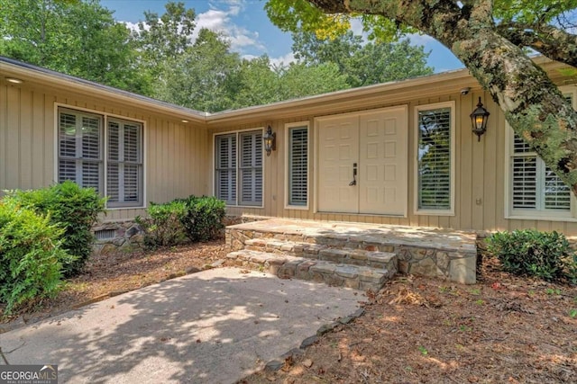 view of exterior entry with a patio