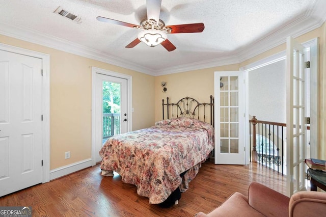 bedroom featuring ornamental molding, wood-type flooring, a textured ceiling, access to exterior, and ceiling fan