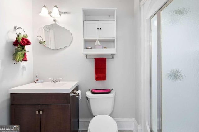 bathroom featuring an enclosed shower, toilet, and vanity