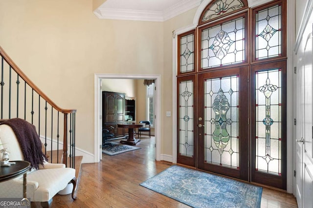 foyer entrance featuring ornamental molding, wood-type flooring, and french doors