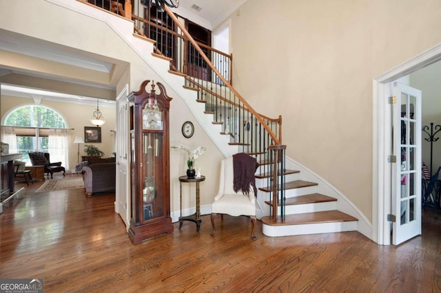 stairs featuring a high ceiling and hardwood / wood-style floors