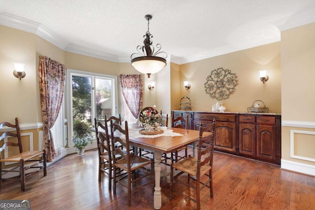 dining room featuring a textured ceiling, ornamental molding, and wood-type flooring