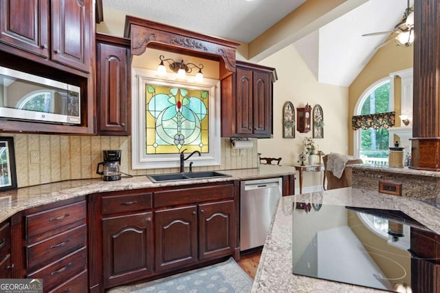 kitchen featuring sink, appliances with stainless steel finishes, light hardwood / wood-style flooring, light stone countertops, and ceiling fan