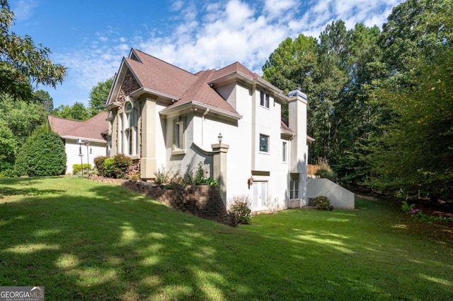 view of side of home with a yard