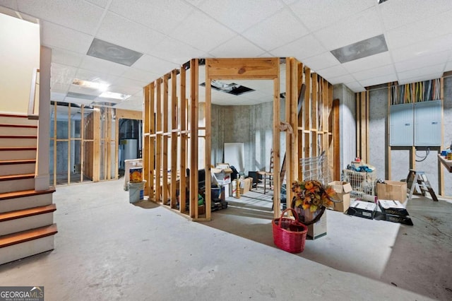 miscellaneous room with a drop ceiling, concrete floors, and electric panel