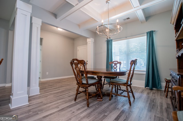 dining area with light hardwood / wood-style floors, coffered ceiling, ornate columns, and an inviting chandelier