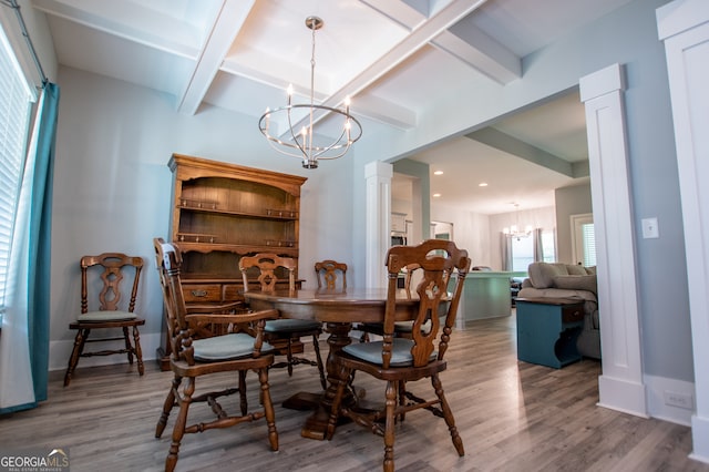 dining space featuring beam ceiling, hardwood / wood-style floors, decorative columns, and a chandelier