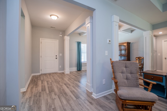 foyer entrance with ornate columns, beamed ceiling, and wood-type flooring