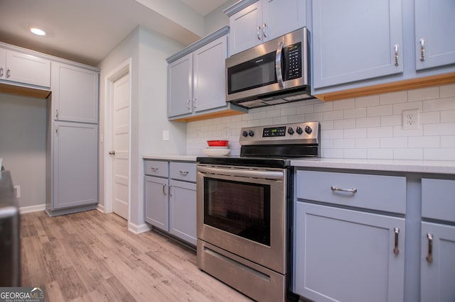 kitchen featuring gray cabinetry, light hardwood / wood-style flooring, and stainless steel appliances