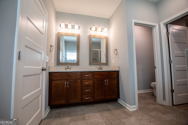 bathroom featuring toilet, dual bowl vanity, and tile patterned floors