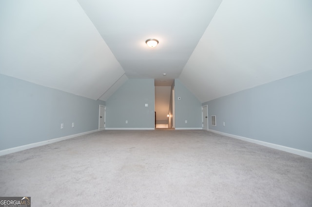 additional living space featuring carpet and vaulted ceiling