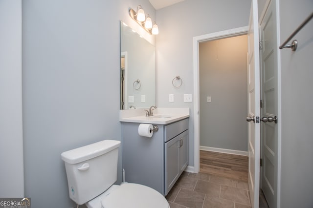 bathroom featuring toilet, hardwood / wood-style flooring, and vanity