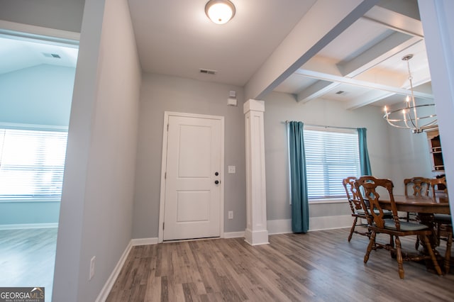 entryway featuring a notable chandelier, lofted ceiling with beams, and wood-type flooring