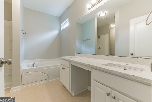 bathroom featuring a tub, dual bowl vanity, and tile patterned floors