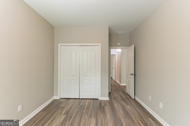 unfurnished bedroom with hardwood / wood-style floors and a closet