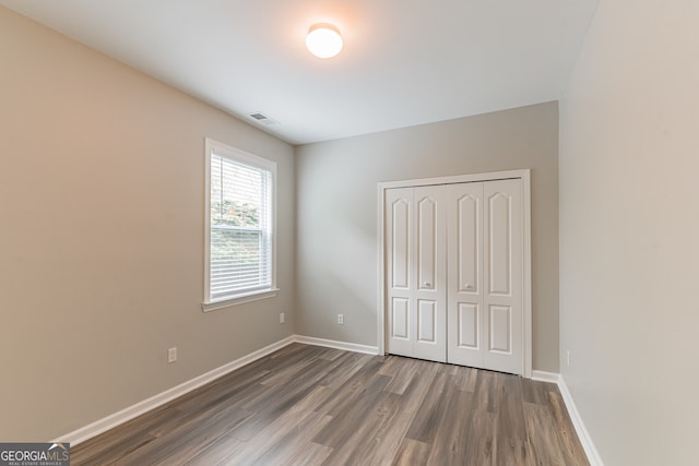 unfurnished bedroom with a closet and hardwood / wood-style floors