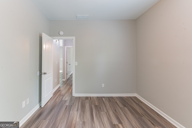 empty room with hardwood / wood-style flooring