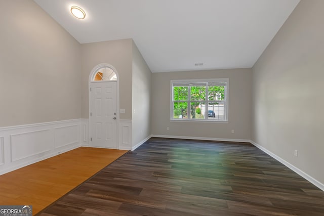 foyer entrance with vaulted ceiling and dark hardwood / wood-style floors