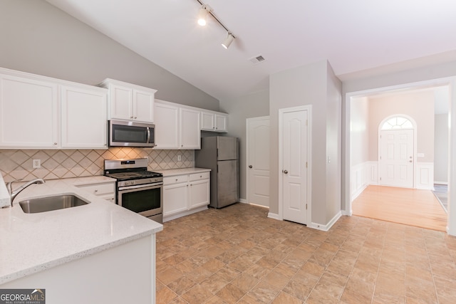 kitchen with light wood-type flooring, light stone countertops, white cabinetry, stainless steel appliances, and lofted ceiling