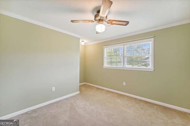 carpeted empty room featuring ceiling fan and crown molding