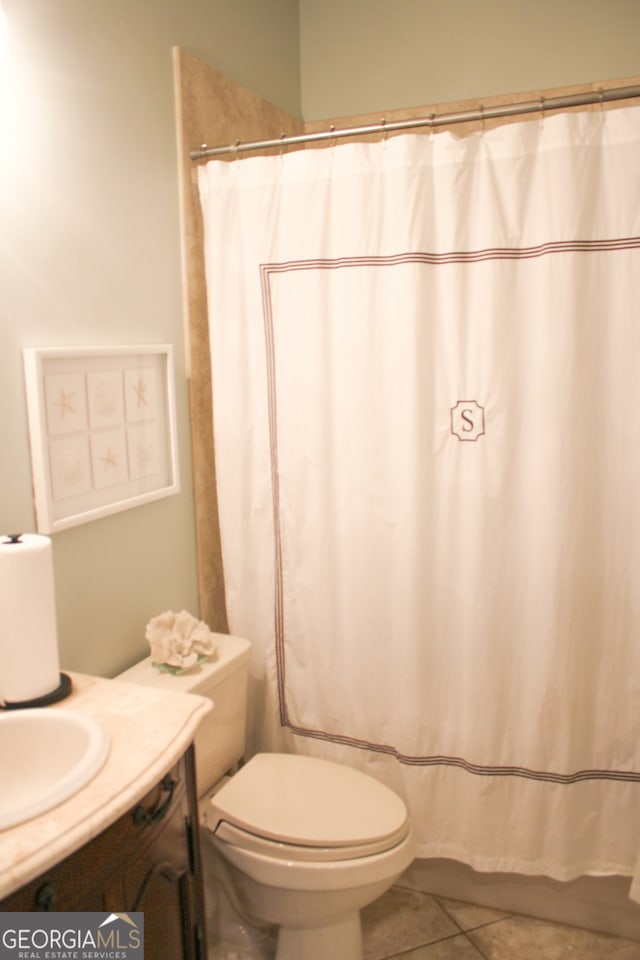 bathroom with curtained shower, vanity, toilet, and tile patterned floors