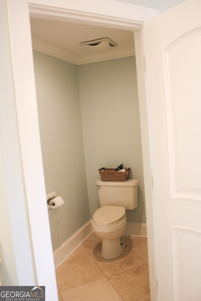 bathroom featuring ornamental molding, tile patterned flooring, and toilet