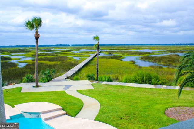 view of property's community with a yard and a water view