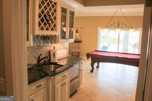 kitchen with cream cabinetry, billiards, tasteful backsplash, pendant lighting, and sink