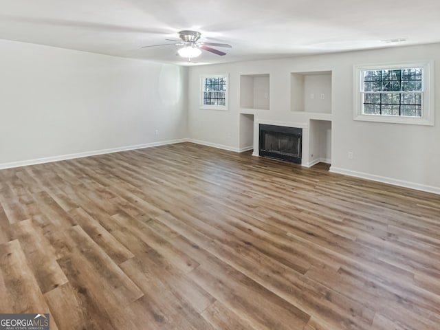 unfurnished living room featuring hardwood / wood-style flooring and ceiling fan