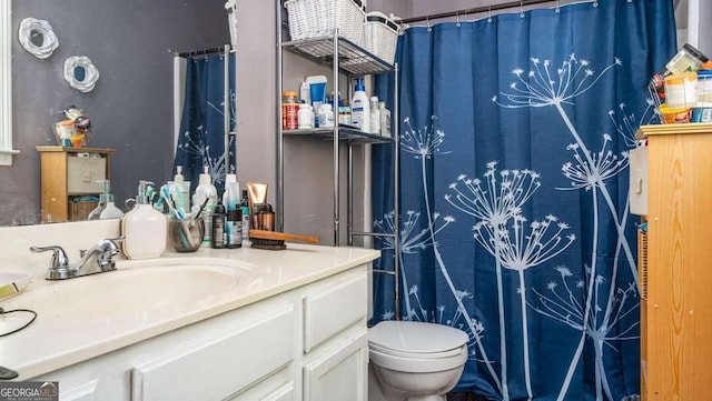 bathroom featuring toilet, a shower with shower curtain, and vanity