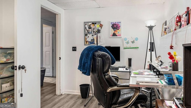 office featuring light hardwood / wood-style flooring and a paneled ceiling