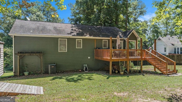 rear view of property featuring central AC unit, a deck, and a yard