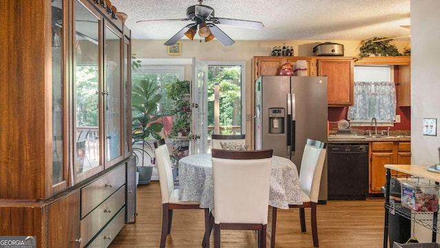 dining space with ceiling fan, light hardwood / wood-style floors, a textured ceiling, and sink