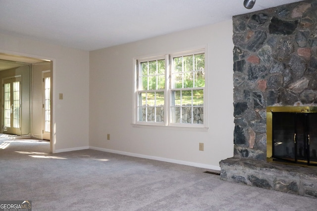 unfurnished living room with light carpet and a fireplace