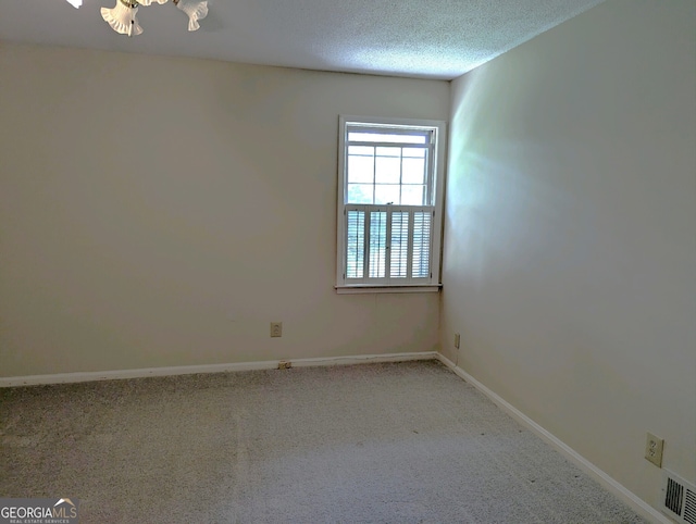 spare room with a textured ceiling and carpet flooring